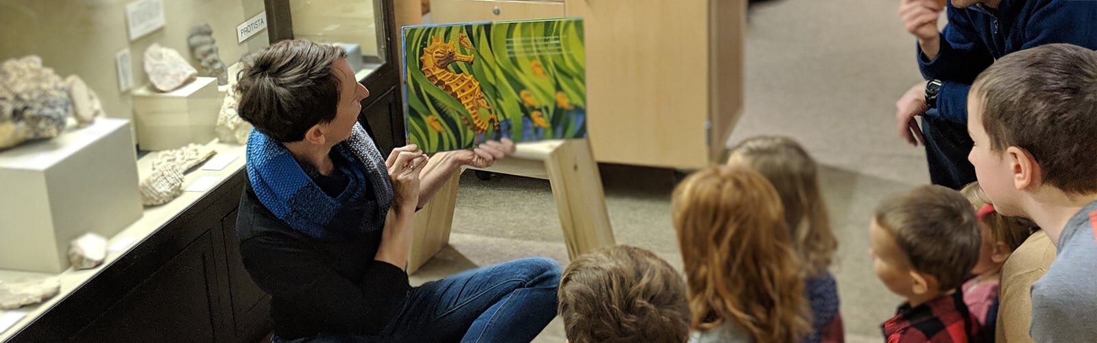 A book about seahorses is read to young visitors.